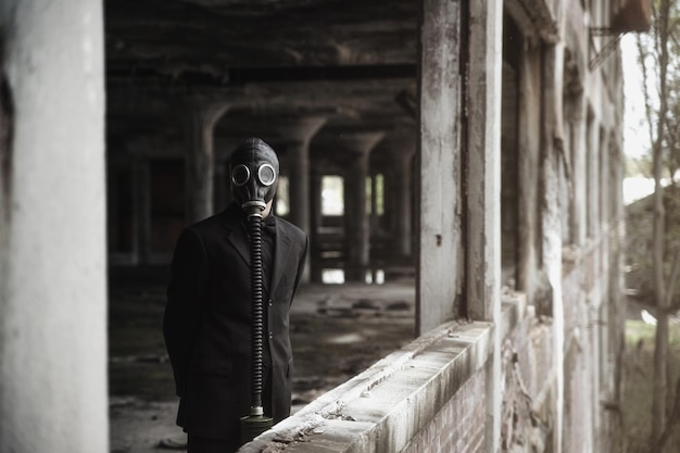Foto man met gasmasker in een verlaten gebouw.