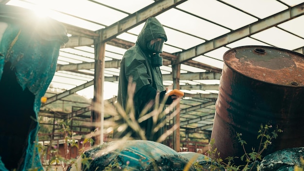 Foto man met geigerteller in de buurt van radioactieve vaten