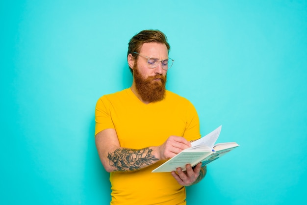 Man met gele t-shirt leest een boek