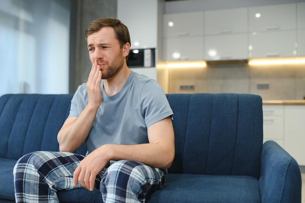 Man met gevoelige tanden die thuis pijn hebben