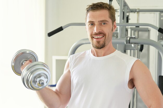 Man met gewichtstraining apparatuur op sport sportschool club