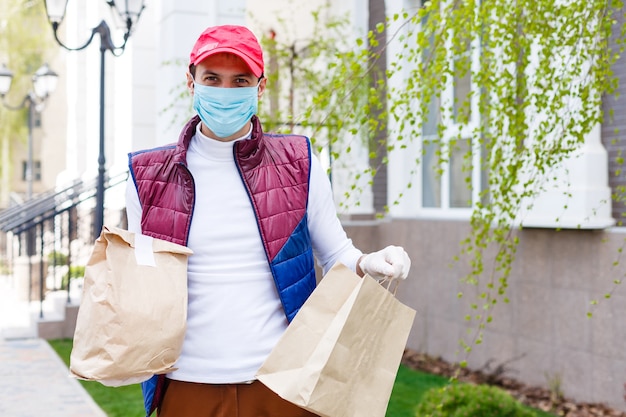 Man met gezichtsmasker levert eten en boodschappen tijdens virusepidemie.