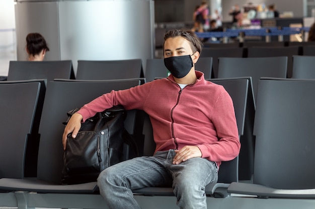 Man met gezichtsmasker op de luchthaven