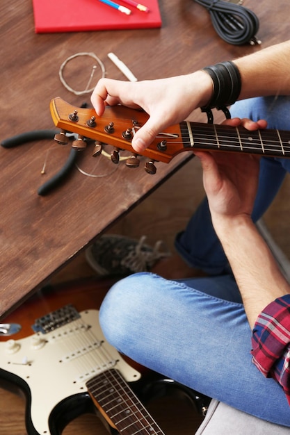 Man met gitaar binnenshuis