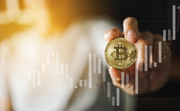 man met gouden bitcoin munt met trading grafiek cryptocurrency concept