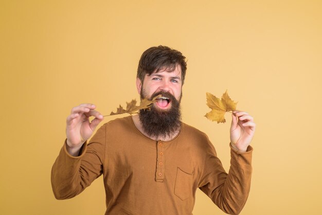 Man met gouden blad herfststemming herfstverkoop herfsttijd man met gele herfstbladeren in de hand