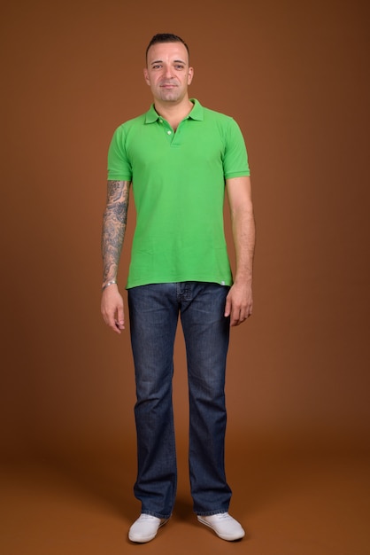 man met groen shirt op bruin