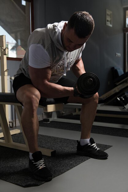 Man met halters die biceps trainen