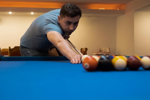 Man met hand op pooltafel snooker spelen of klaar om biljartballen snooker te schieten