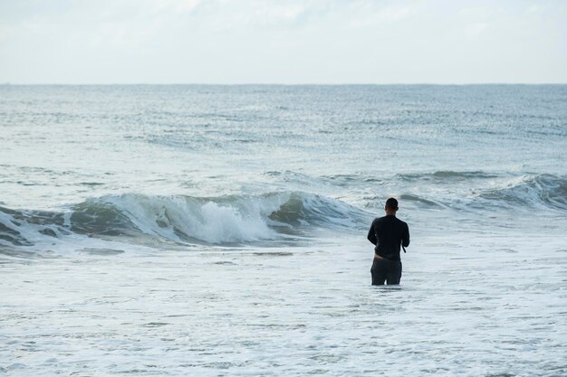 Man met hengel op het strand