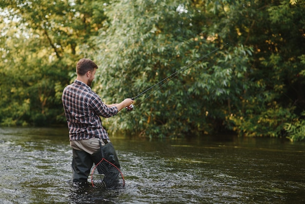 Man met hengel visser mannen in rivierwater buiten Forel vissen in net Zomer vissen hobby