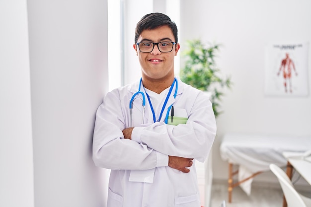 Man met het syndroom van Down in doktersuniform met gekruiste armen in de kliniek