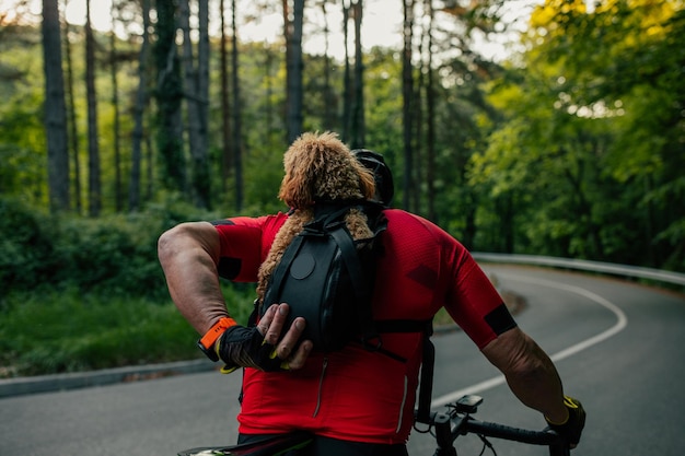 Man met hond in rugzak hondendraagtas op een fietstocht