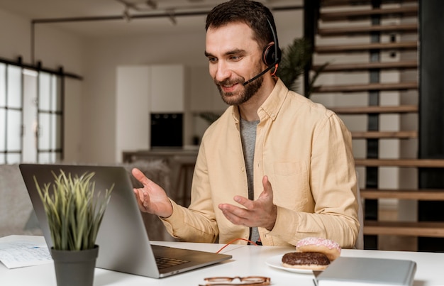 Man met hoofdtelefoon met video-oproep op laptop