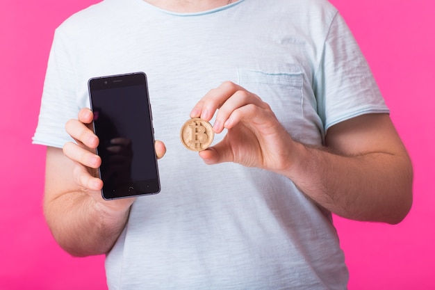 Man met houten bitcoin en leeg scherm mobiele telefoon close-up