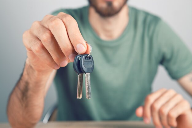 Man met huissleutels op grijze achtergrond