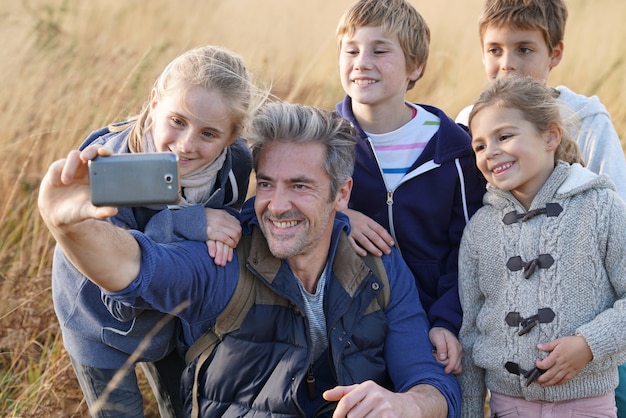 Man met kinderen in het veld nemen selfie foto