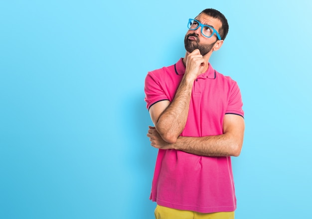 Man met kleurrijke kleding denken op kleurrijke achtergrond