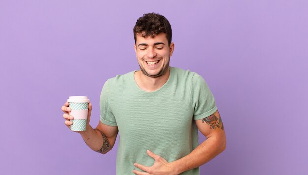 Man met koffie die hardop lacht om een hilarische grap, zich gelukkig en opgewekt voelt, plezier heeft