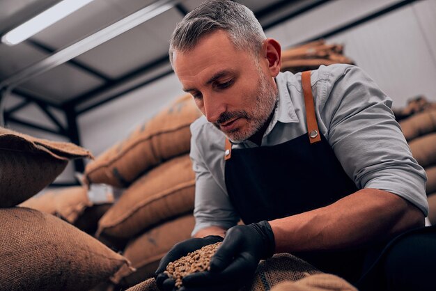 Man met koffiebonen en geniet van het aroma Close-up bekijken