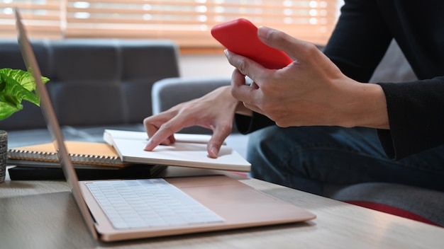 Man met laptop en smartphone op de bank