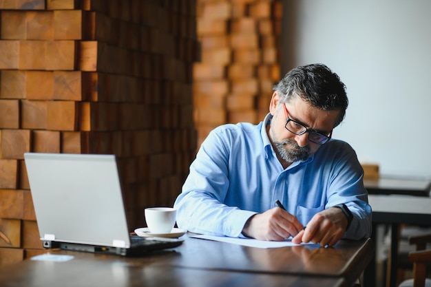 Man met laptop in café-bar