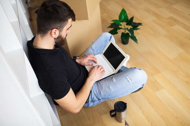 Man met laptop in nieuw huis