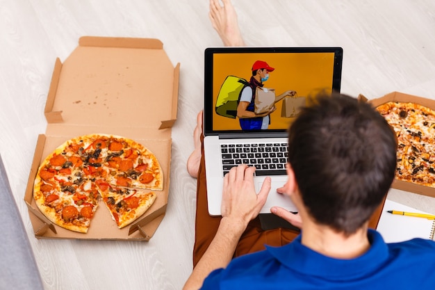 Foto man met laptop voor online eten bestellen tijdens quarantaine, close-up. bezorgservice