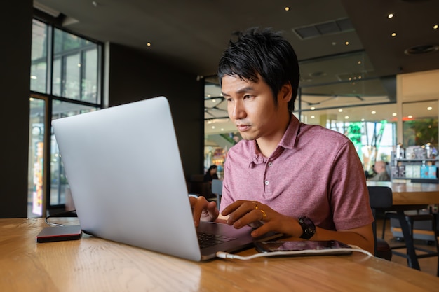 Man met laptopcomputer in café