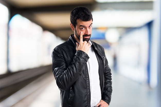 Man met lederen jas die iets op ongerichte achtergrond laat zien