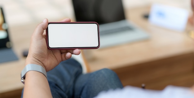 man met leeg scherm smartphone zittend op een comfortabele werkplek