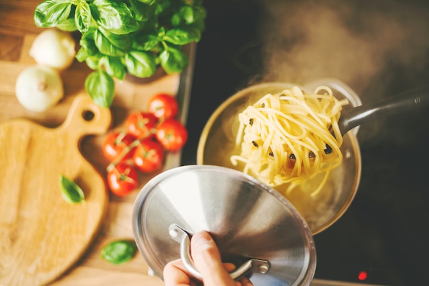 Man met lepel met stomende pasta