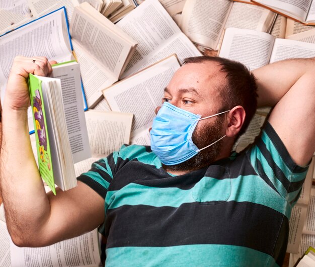 Man met medisch masker met veel papieren boeken