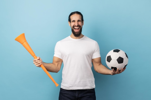 Man met megafoon en voetbal die de overwinning van het favoriete voetbalteam viert