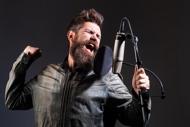 Man met microfoon die lied zingt Muzikant in muziekzaal Expressieve zanger met microfoon Grappige kerel die in karaoke zingt