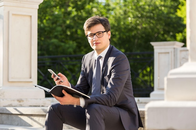 Man met notitieblok en telefoon