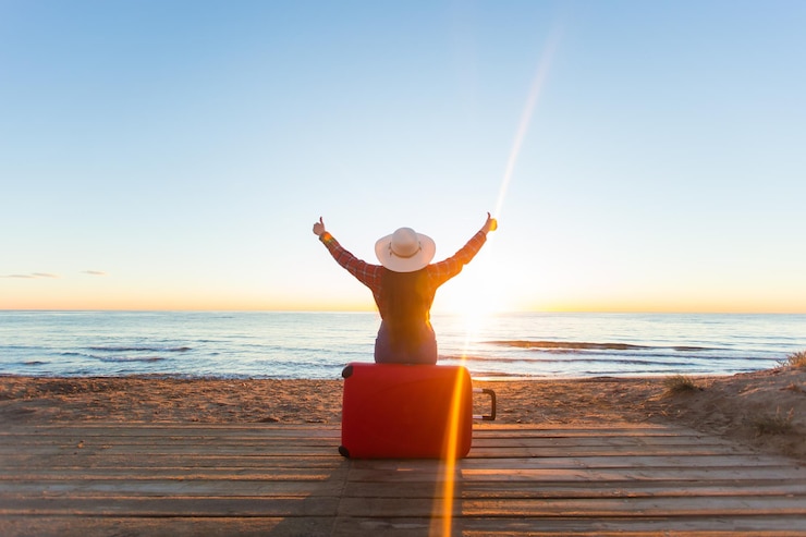 Foto man met opgeheven armen op het strand tegen een heldere lucht