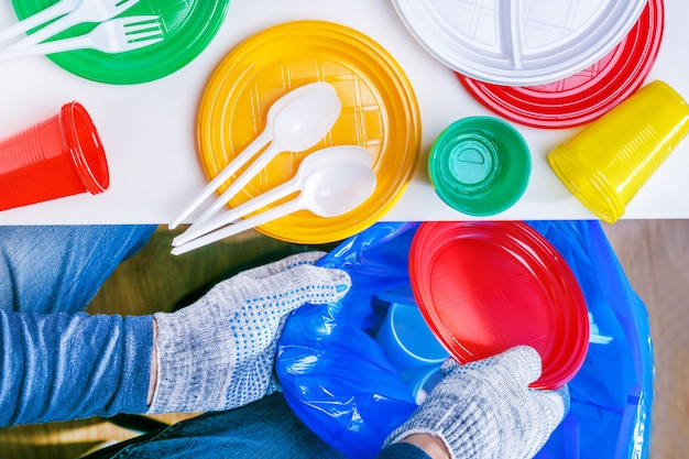 Man met plastic schalen in een plastic zak