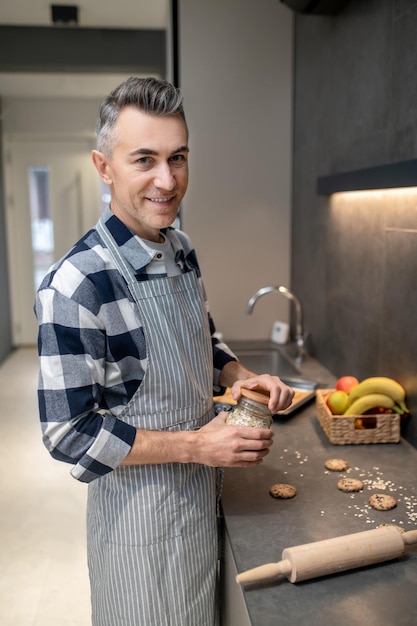 Man met pot amandelschijfjes die naar de camera kijkt