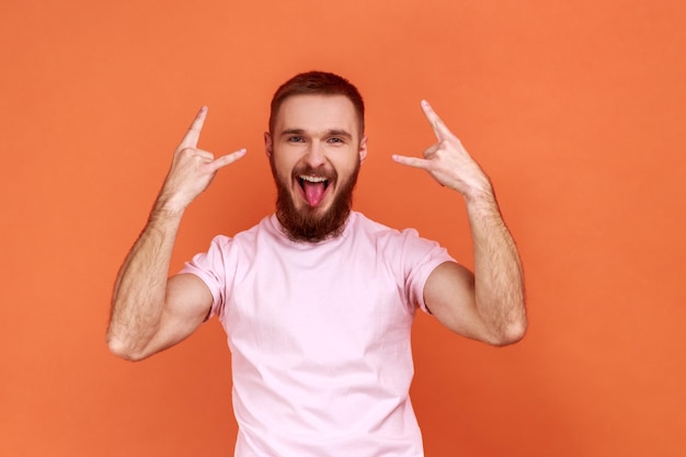 Man met rock-'n-roll teken handgebaar kijkend naar camera met tong uit opgewonden uitdrukking