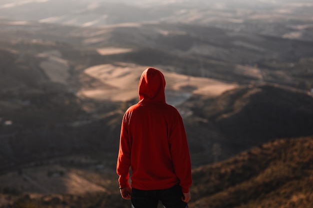 Man met rode sweater met wazig landschap