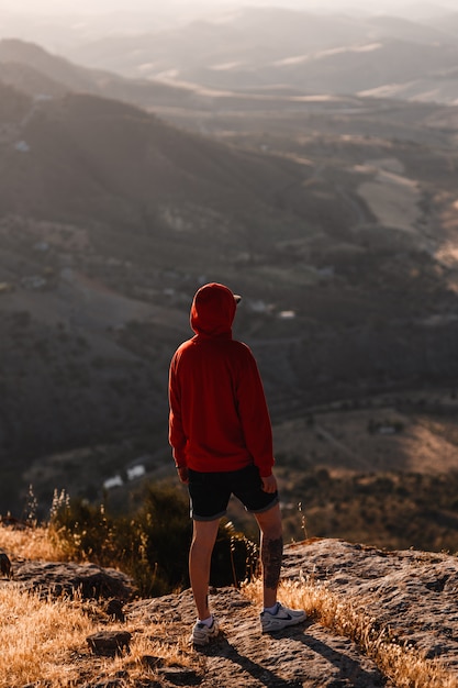 Foto man met rode sweater met wazig landschap