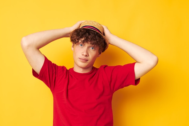 Man met rood krullend haar emoties rode t-shirt hoed studio gele achtergrond ongewijzigd