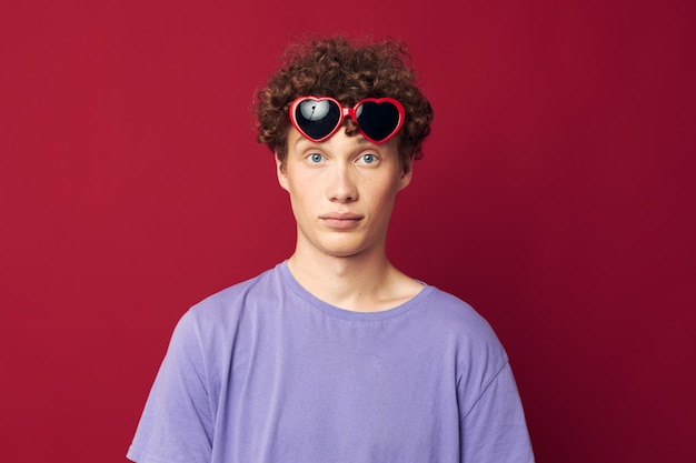 Man met rood krullend haar handgebaren hartvormige bril poseren geïsoleerde achtergrond