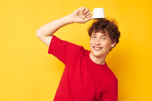 Man met rood krullend haar witte mok in de handen van een drankje gele achtergrond ongewijzigd