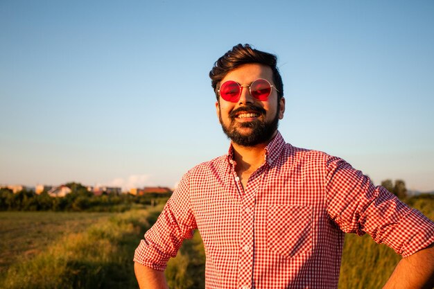 Man met roze bril geniet van zonnig weer