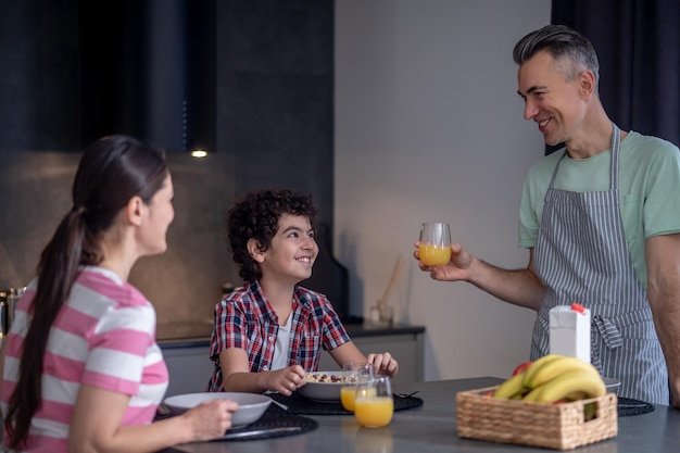 Man met sap kijkend naar vrouw en jongen