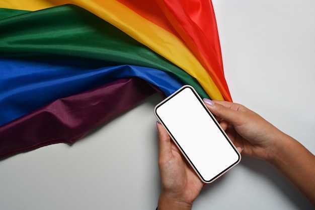 Man met slimme telefoon met regenboogvlag LGBT-concept