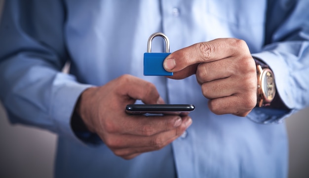 Foto man met smartphone met een hangslot. veiligheid