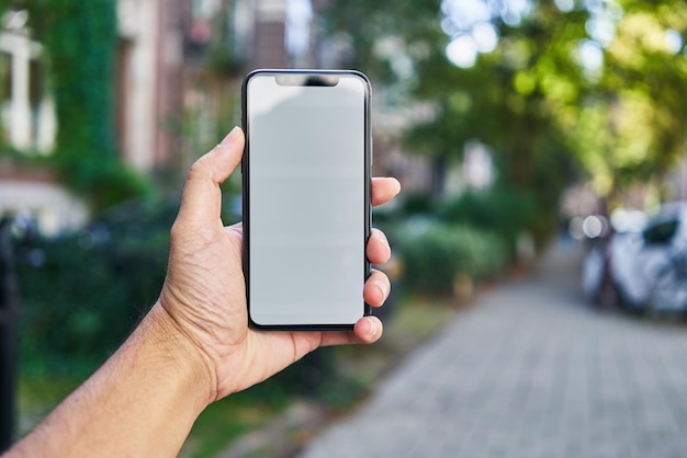 Man met smartphone met wit leeg scherm op straat